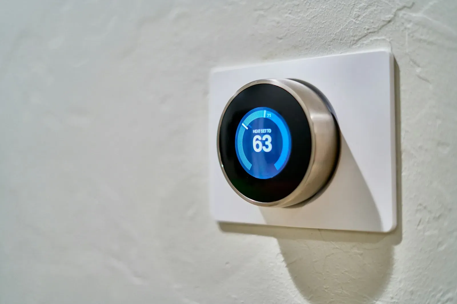 Thermostat connecté fixé sur un mur clair
